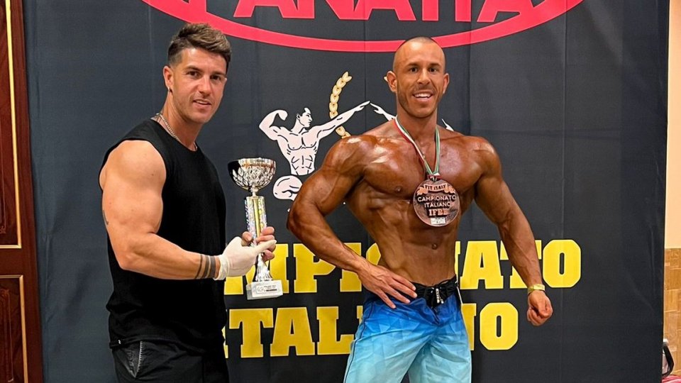 A destra, Michele Giannoni con al collo la medaglia del terzo posto e accanto la coppa del secondo posto.