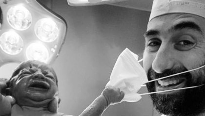 Il neonato toglie la mascherina al medico: chi è il ginecologo della foto della speranza?